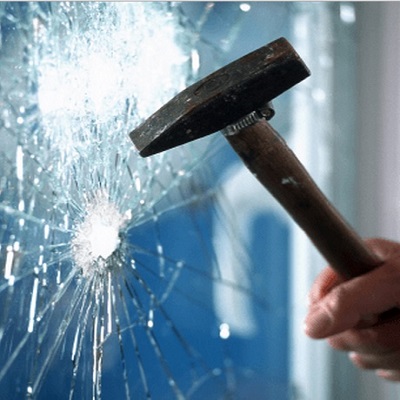 Thief breaking a window with a hammer  (Image for illustrative purposes only)