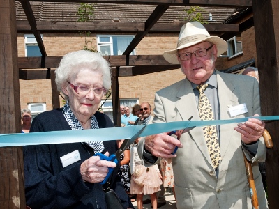 Cynthia Haynes and Trevor Cook concentrate hard and take their marks before cutting the ribbon to launch the new garden at TDHA Windmill Road