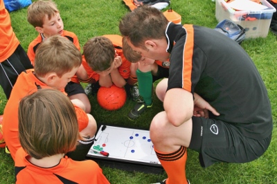 Neil Yates discusses tactics with some of his U9 squad