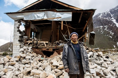 Phur Tenzing Sherpa stands in front of what was his home in the village of Thame (image courtesy of Dave Morton of The Juniper Fund)