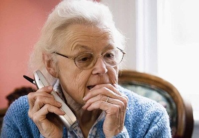 Worried and pensive senior woman talking on cordless phone. Image shot 2006. Exact date unknown.