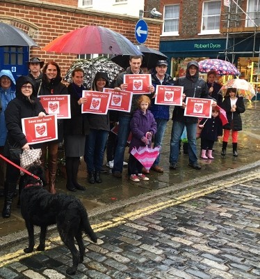 A group of local people demonstrate in the rain, their opposition to an edge-of-town supermarket in Thame 