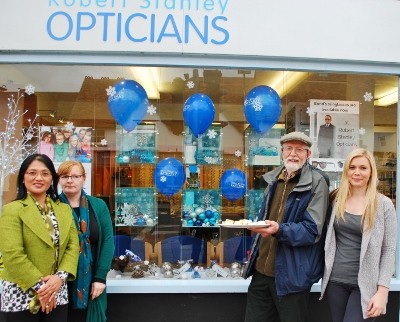 Cllr David Laver shares the 'Rising Star High Street' cake with staff at Robert Stanley Opticians who decorated their shop window to celebrate Small Business Saturday